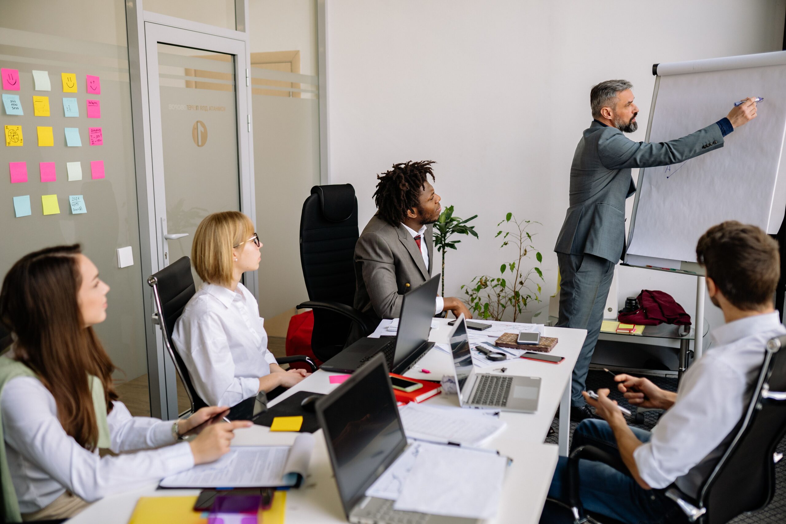 person gesturing during meeting with laptop
